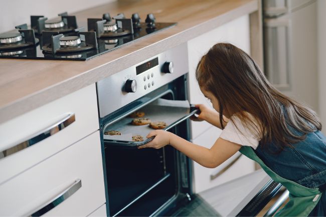 uma pessoa utilizando forno de um fogão